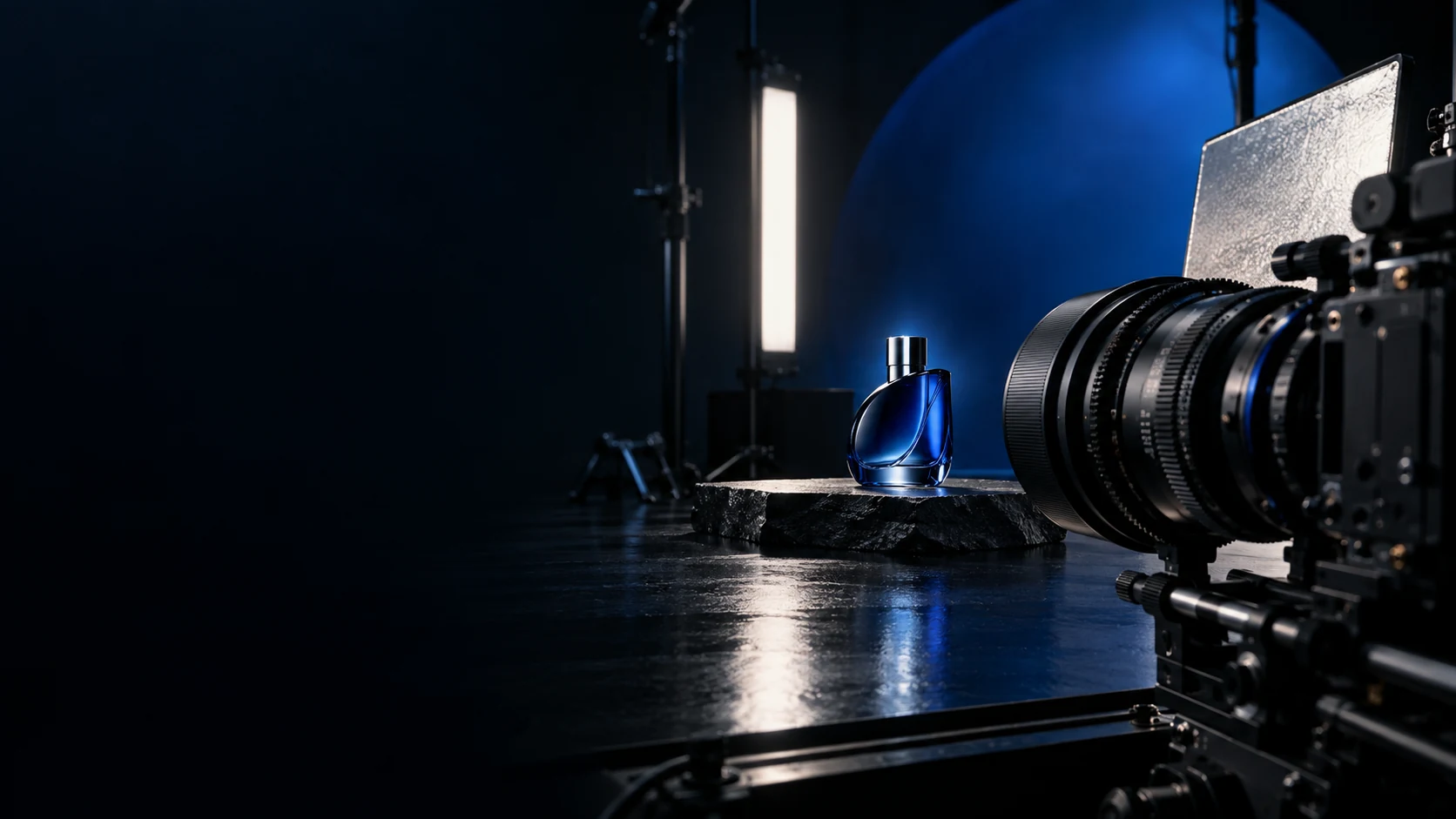 Filmische Gestaltungsstudie mit Kamera, Studiolicht und einem tiefblauen Glasprodukt.